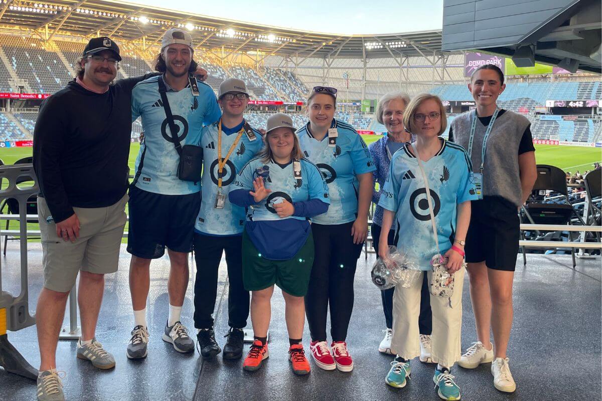 Group of people posing for a photo at a MNUFC soccer game