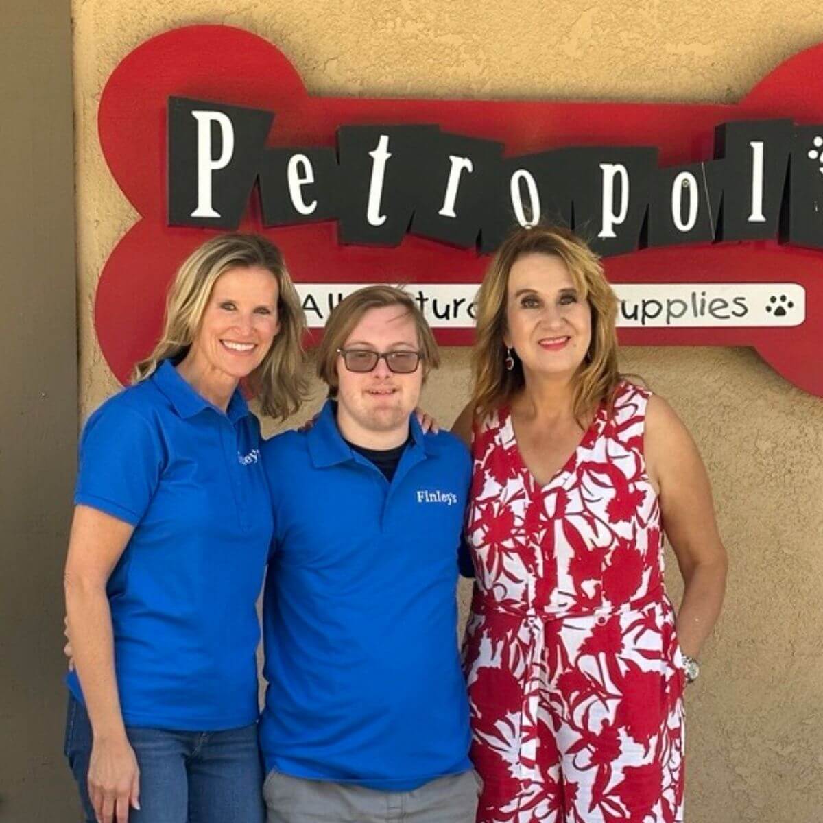 Three people standing in front of a 'Petropolis' sign